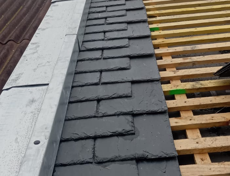 pose d'ardoises sur couverture toiture en cours de chantier avec voligeage bois