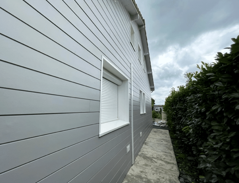bardage bois gris en lames horizontales sur façade de maison contemporaine avec volet roulant blanc