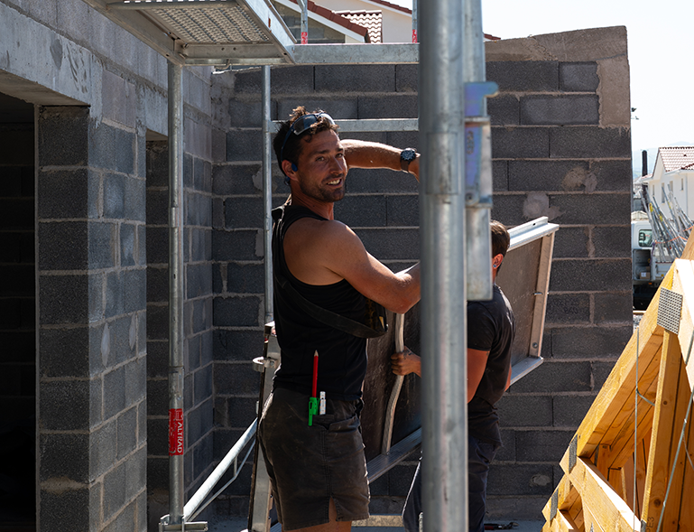 compagnon charpentier souriant sur chantier de construction neuve en parpaing