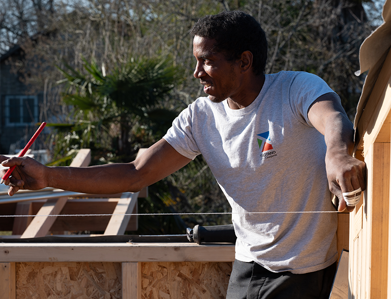 charpentier Troyano Charpente tendant un cordeau pour aligner la charpente bois sur chantier
