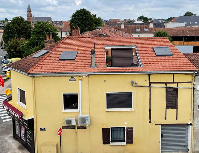 couverture toiture en tuile rouge avec fenêtres de toit Velux sur immeuble en centre-ville de Vic-en-Bigorre
